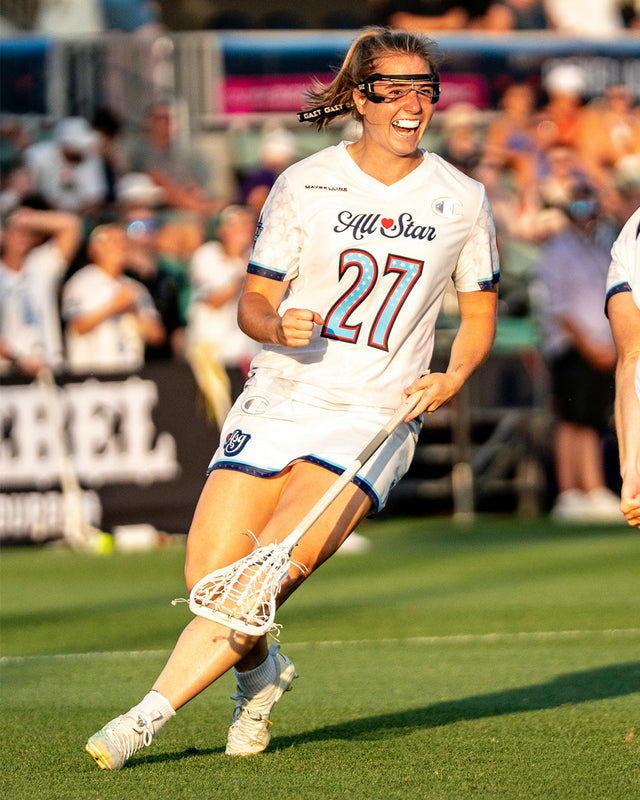 Women's lacrosse player carrying the ball during a game