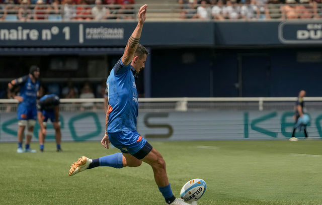 Rugby player kicking the ball during a match